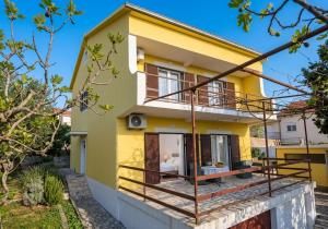 a yellow house with a balcony at Отрада in Utjeha +2 photos