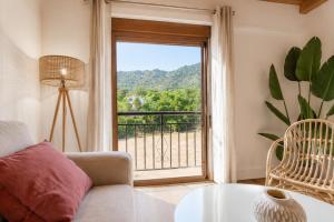 a living room with a couch and a large window at Duplex El Acebuche in Arroyo Frio