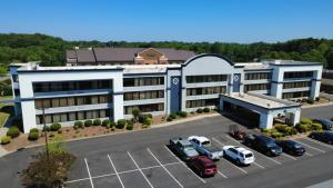 a large building with cars parked in a parking lot at SureStay by Best Western Charlotte Matthews in Matthews