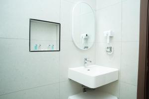 a white bathroom with a sink and a mirror at Horizon Stay Nizwa in Firq +81 photos