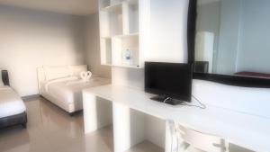 a white room with a desk with a television on it at ibeyond Apartment Romklao Suvarnabhumi in Lat Krabang