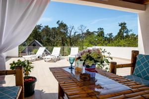 a wooden table with flowers on a patio at VILLA EVA - 5 min to the beach in Shekhvetili