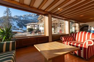 a room with two chairs and a table and a window at Hotel Miramonti Corvara in Corvara in Badia