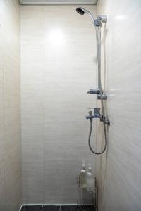 eine Dusche mit Duschkopf im Badezimmer in der Unterkunft Lazy Cube in Seoul