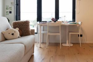a living room with a table and a teddy bear on a couch at Cozy Rooftop - Sint-Idesbald in Koksijde