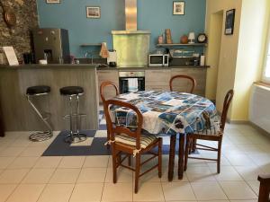 a kitchen with a table and chairs and a kitchen with a stove at Casa Defranchi in Sant Andrea di Bozio +9 photos