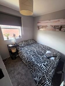 a bedroom with a black and white bed with a window at Clover Ground Home in Bristol