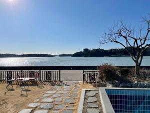 a swimming pool next to a body of water at Daeboodo Prince Pension in Ansan