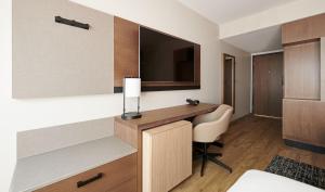a hotel room with a desk and a television at Hyatt Place Guyana Georgetown in Georgetown