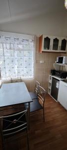 a small kitchen with a table and a table and a chair at Paralelo46 in Chile Chico +6 photos