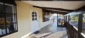a porch of a house with a white door and windows at Paralelo46 in Chile Chico