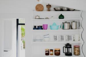 a shelf filled with cups and utensils at Casa Lucia Green Cottage in Corfu