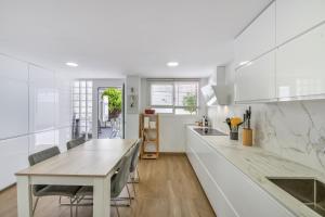 a kitchen with white cabinets and a wooden table at Alcaidesa Golf in La Alcaidesa
