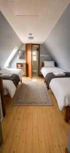 a attic bedroom with two beds and a rug at Wild Rowan Cottage - 2 Bedroom in Louisburgh