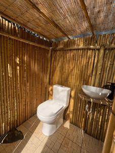 a toilet and a sink in a bamboo bathroom at Bulle d'Alma - Bio climatique in Sotta
