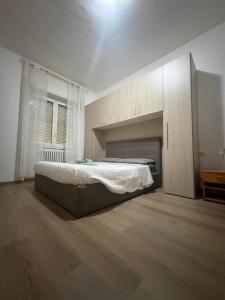 a bedroom with a large bed and a wooden floor at Casa del Pepo in Segrate +6 photos