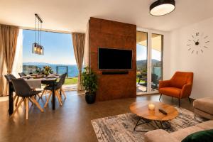 a living room with a television and a table with chairs at Visum Residence Labin - Luxury sea view retreat in Labin
