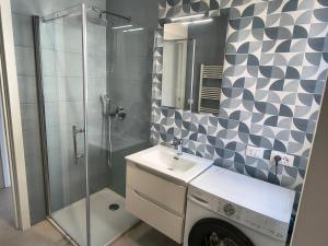 a bathroom with a shower and a sink and a washing machine at Casa Bolina in Senigallia +3 photos