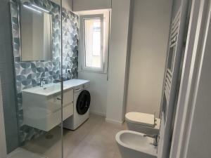 a bathroom with a sink and a washing machine at Casa Bolina in Senigallia