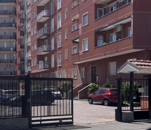 a gate in front of a building with a parking lot at Casa del Pepo in Segrate