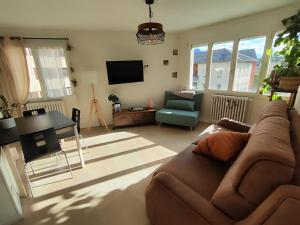 a living room with a couch and a table at Charmant T2 in Embrun