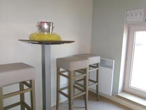 a kitchen with two stools and a table and a window at huisje Kraaiberg in Heuvelland +8 photos
