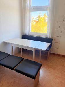 a table and two seats in a room with a window at Ferienhaus Jamshidi in Waren