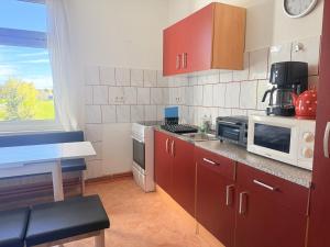 a kitchen with red cabinets and a microwave at Ferienhaus Jamshidi in Waren