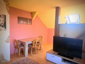 a dining room with a table with chairs and a television at Ferienhaus Jamshidi in Waren +6 photos