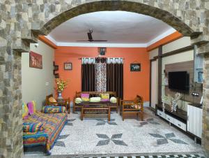 a living room with orange walls and a couch at Anjali Homestay - 10 mins from Bagdogra airport in Siliguri