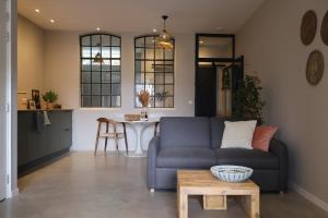 a living room with a blue couch and a table at B&B de Beurtvaart in Dokkum