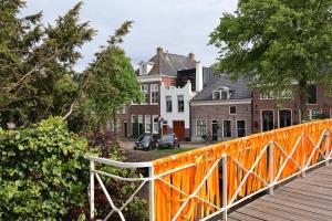 an orange bridge over a street with houses at B&B de Beurtvaart in Dokkum