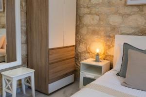 a bedroom with a bed and a mirror and a table at Old Luxury Stone House Armou in Armu