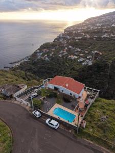 an aerial view of a house with a swimming pool at Loreto Rose, Panoramic Ocean and Mountain View in Arco da Calheta