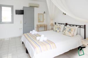 a bedroom with a large bed with two white towels at Hotiday Santorini Seafront in Santorini