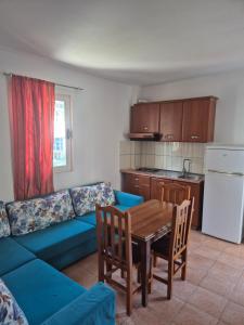 a living room with a blue couch and a table at Rooms and Apartments Analipsi in Shëngjin