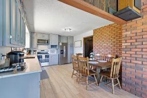 a kitchen with a table and a brick wall at Hiwassee Lake Lodge - Private Mtn-Top Retreat - Lake Views - Sleeps 14 in Murphy