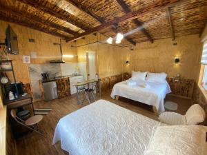 a bedroom with two beds and a kitchen in it at Departamentos Eldestino in Puerto Puyuhuapi