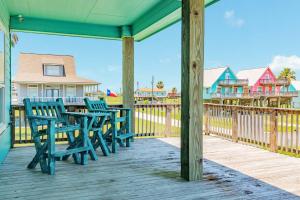 a porch with two chairs and a table on a deck at Steps from the Jetty & Beach in Surfside Beach