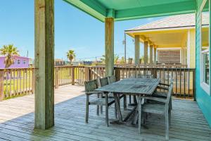 a wooden deck with a wooden table and chairs at Steps from the Jetty & Beach in Surfside Beach