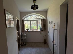 a hallway with an arched window and a window sill at Viesu māja Gulbji in Bigauņciems +7 photos