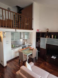a living room with a table and a kitchen at VeronaVera Porta Palio Panoramic Loft in Verona +11 photos