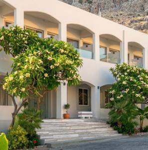 a building with trees in front of it at Pals Studios Pefkos in Pefki