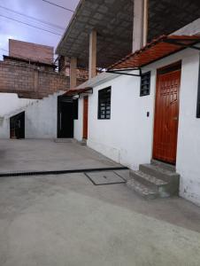 a white building with a red door and a driveway at Huset södra Quito in Quito