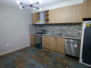 a kitchen with a sink and a stove top oven at Huset södra Quito in Quito