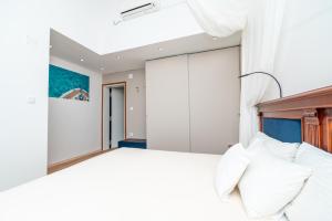 a bedroom with white walls and a bed with white pillows at Captain's Escape - Spa City View in Mali Lošinj +46 photos