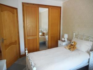 a teddy bear sitting on a bed in a bedroom at Dripshill Lodge in Severn Stoke
