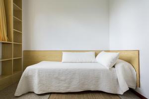 a white bed with a white comforter and pillows at Residencia Universitaria Siglo XXI in Culleredo