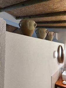 three vases sitting on top of a wall at Monte da Palmeira in Vila Nova da Baronia