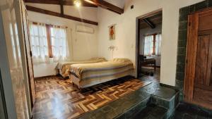 a bedroom with two beds and a wooden floor at Sayacuna Huasi Cabañas in Tafí del Valle +30 photos